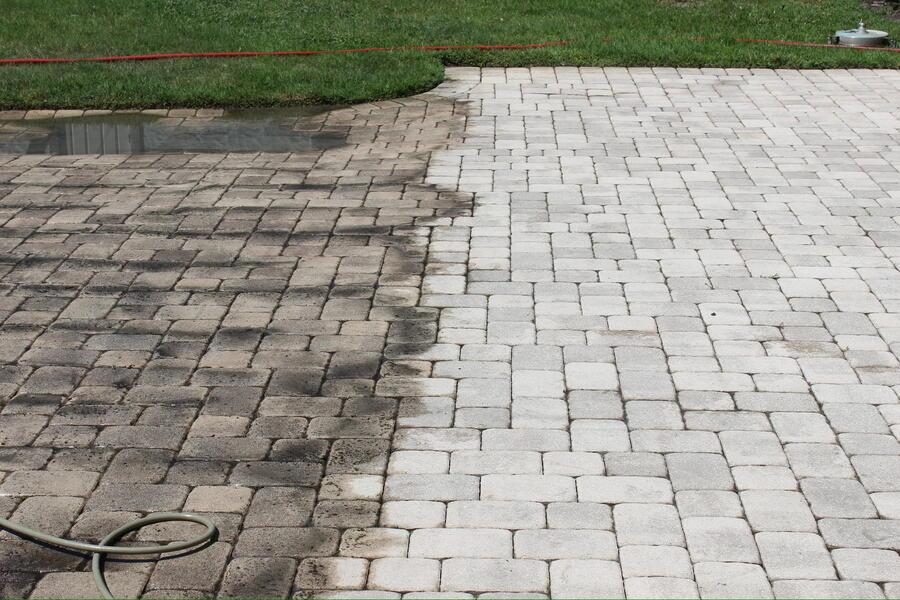 Brick paver surface after low-pressure cleaning beside a planter, joint sand undisturbed, Central Florida